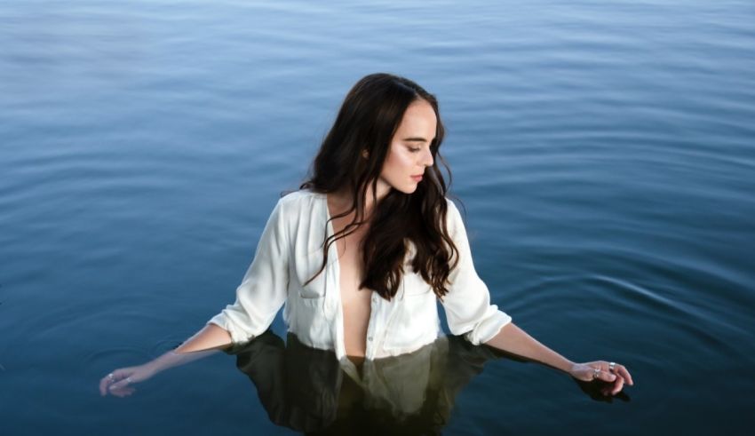 A woman in a white shirt floating in the water.