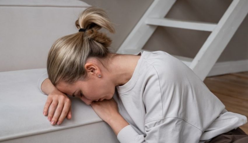 A woman lying on the floor with her head resting on her hand.