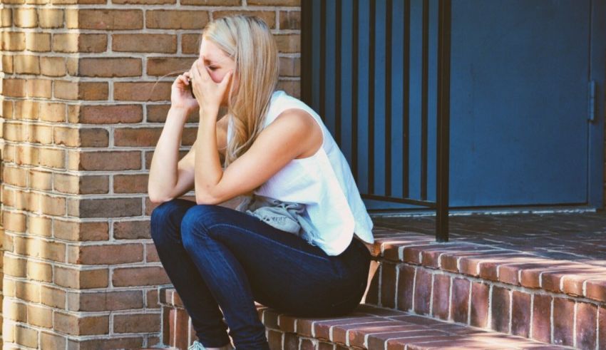 A young woman sitting on the steps of a building.