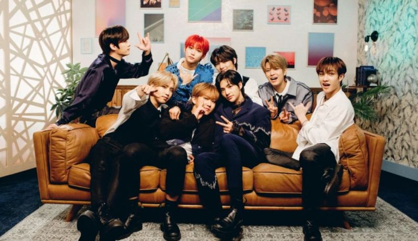 The bts boys are posing on a brown couch.