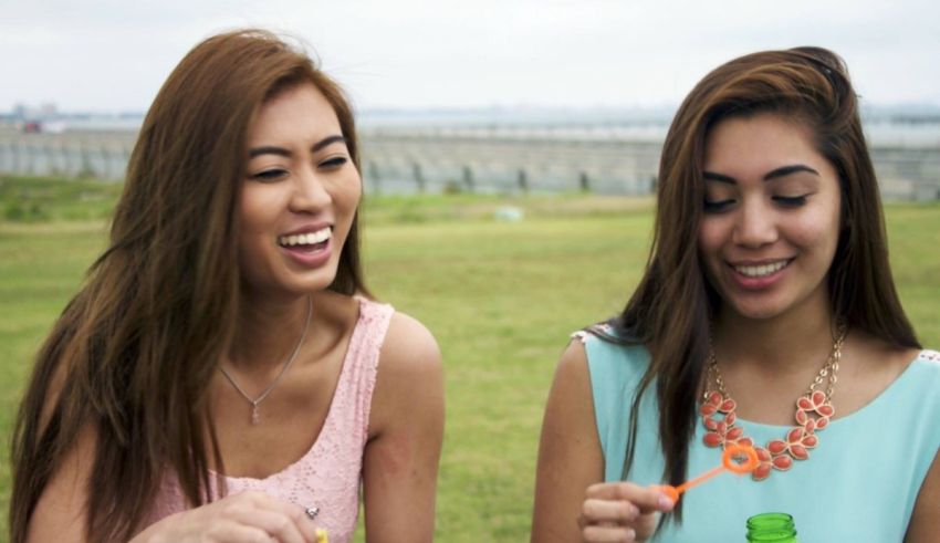 Two asian girls eating ice cream in a park.