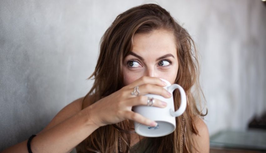 A young woman drinking a cup of coffee.