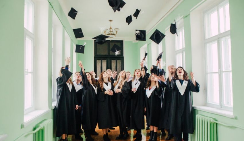 A group of women in graduation gowns tossing their hats in the air.