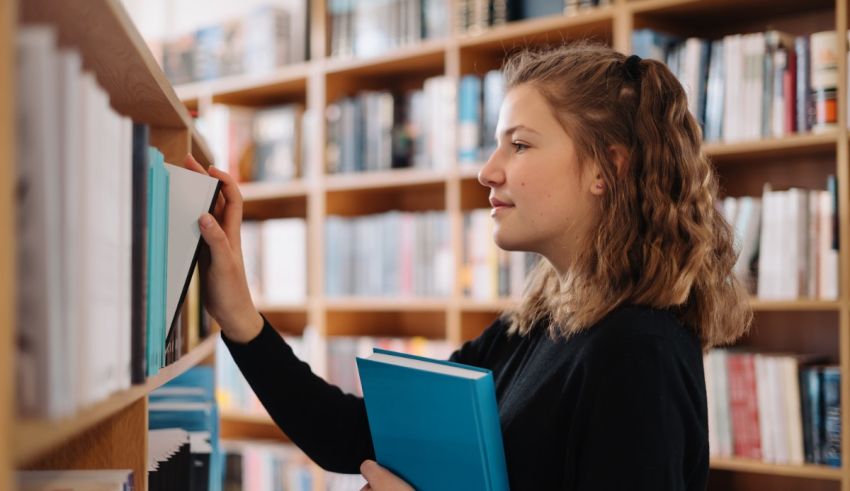 A young woman looking at books in a library.