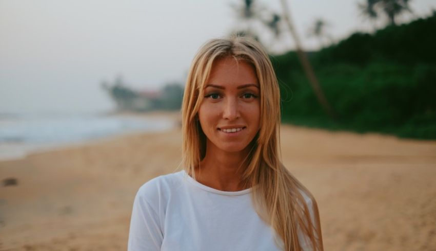 A blonde woman standing on a beach.