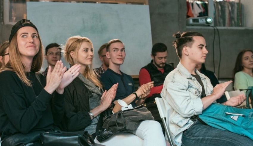 A group of people clapping at an event.