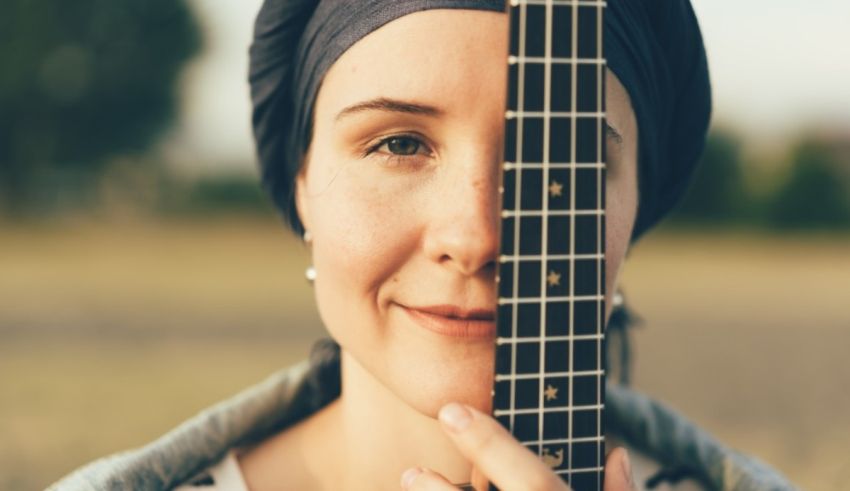 A woman wearing a turban and holding an acoustic guitar.