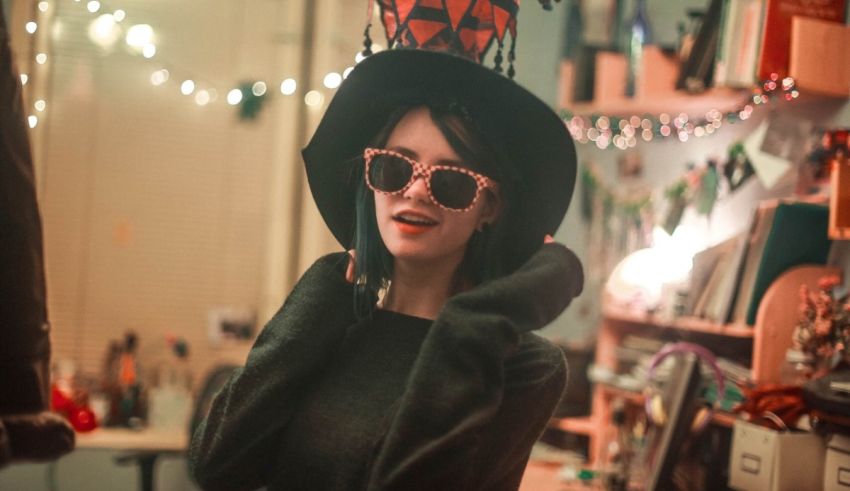 A woman wearing a hat and sunglasses in a room.