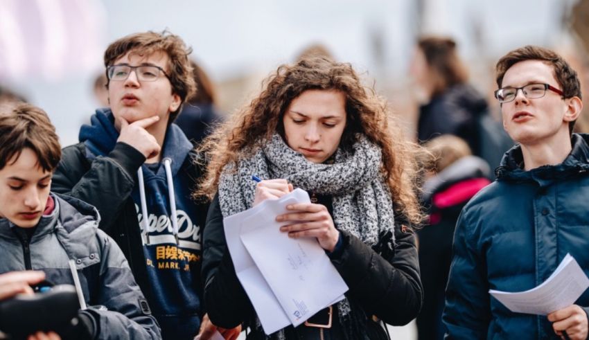 A group of people looking at papers in a crowd.