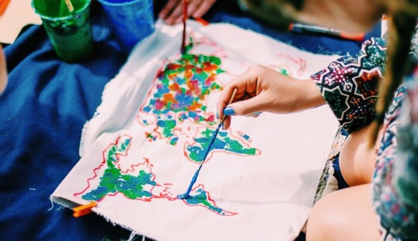 A girl is painting a map on a piece of cloth.