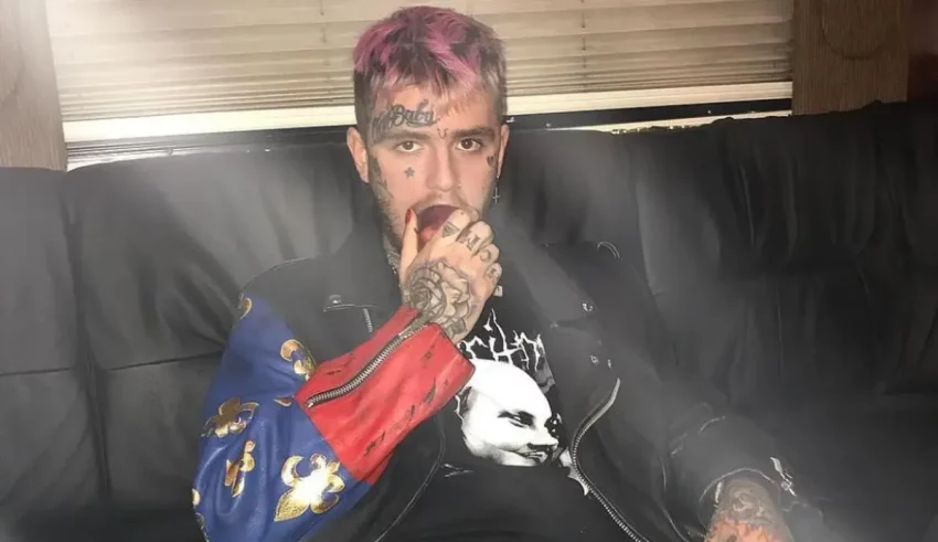 A man with pink hair sitting on a couch.