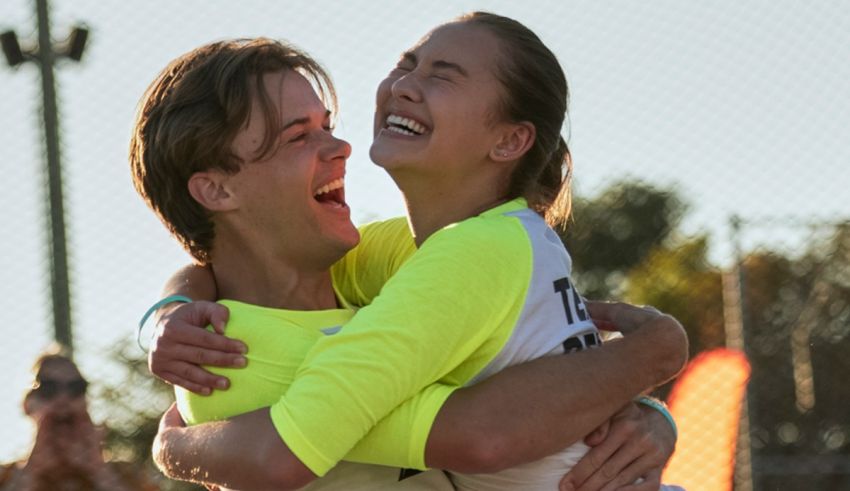 Two people hugging on a soccer field.