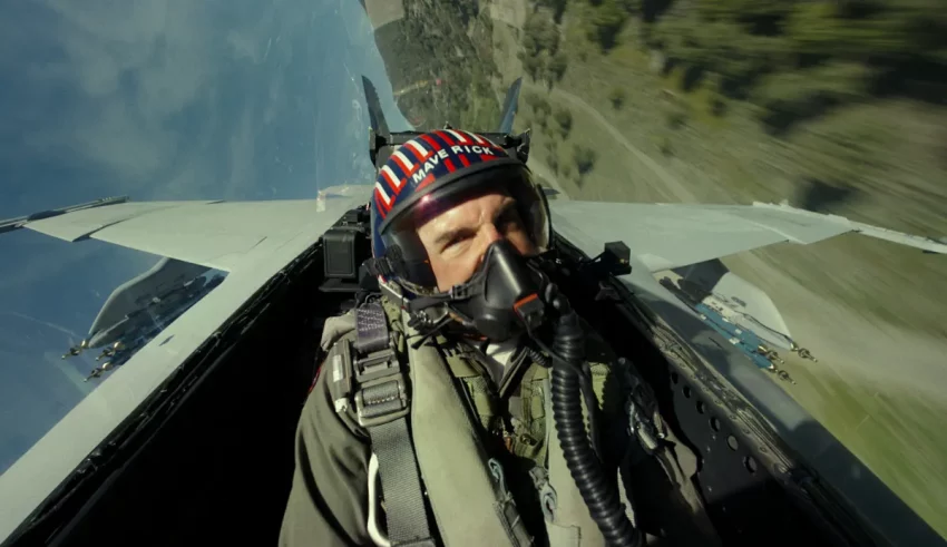 A man is flying a fighter jet with a helmet on.