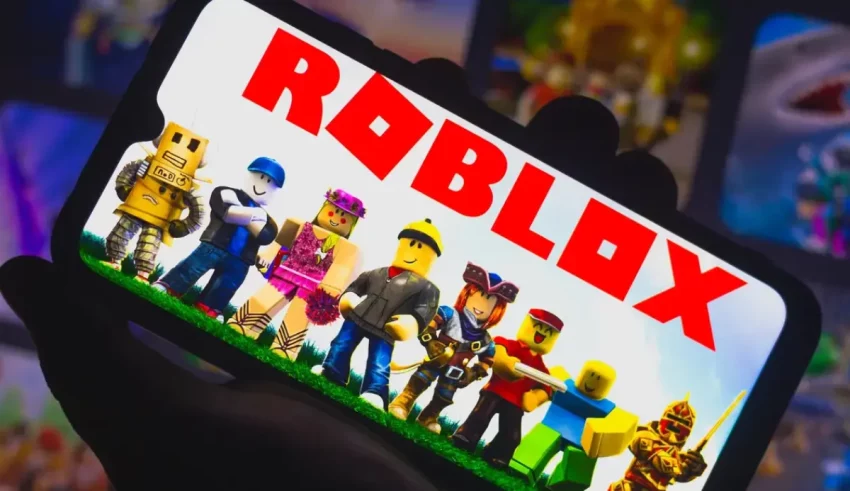 A person holding up a phone with the word roblox on it.