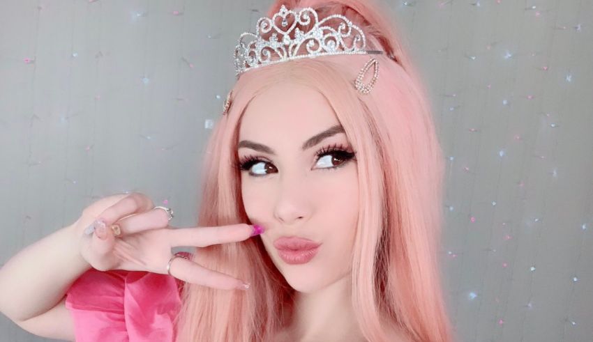 A girl with pink hair and a tiara posing for a picture.