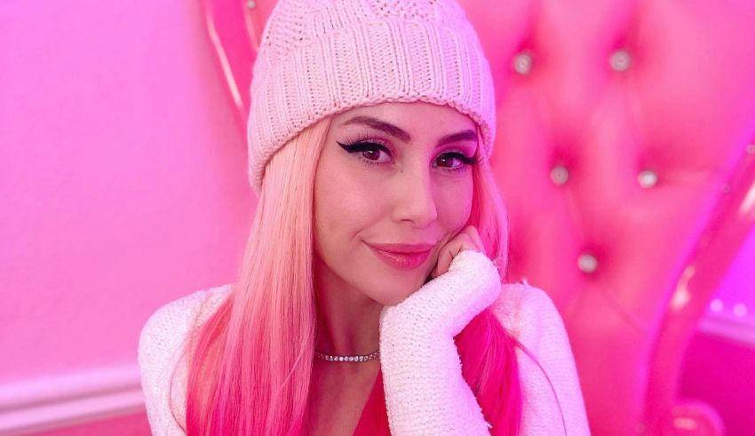 A woman with pink hair posing on a pink chair.