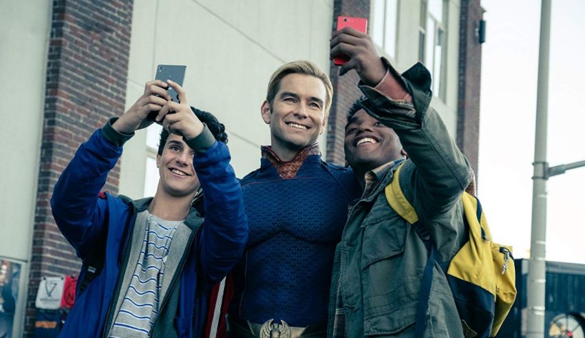 A group of young men taking a selfie with a cell phone.