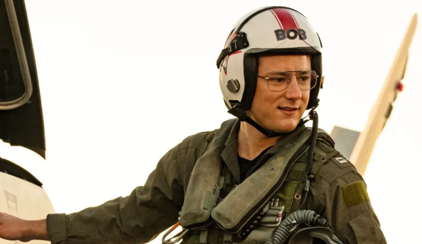 A man in a military uniform standing next to a plane.