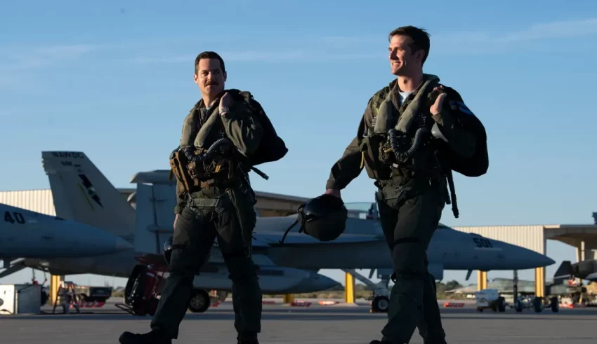 Two air force men walking in front of planes.