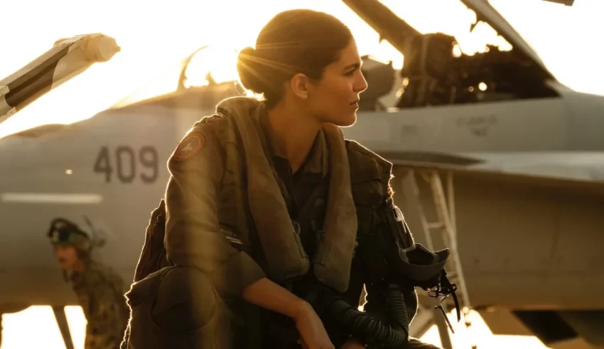 A woman in a military uniform standing next to an airplane.