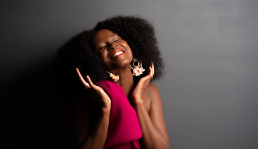 A young african woman with afro hair posing for a photo.