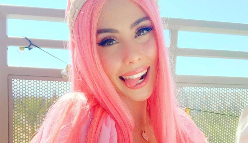 A woman with pink hair is posing for a photo.