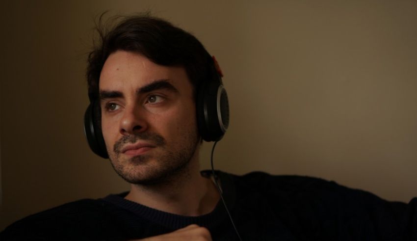 A man wearing headphones and staring at the camera.