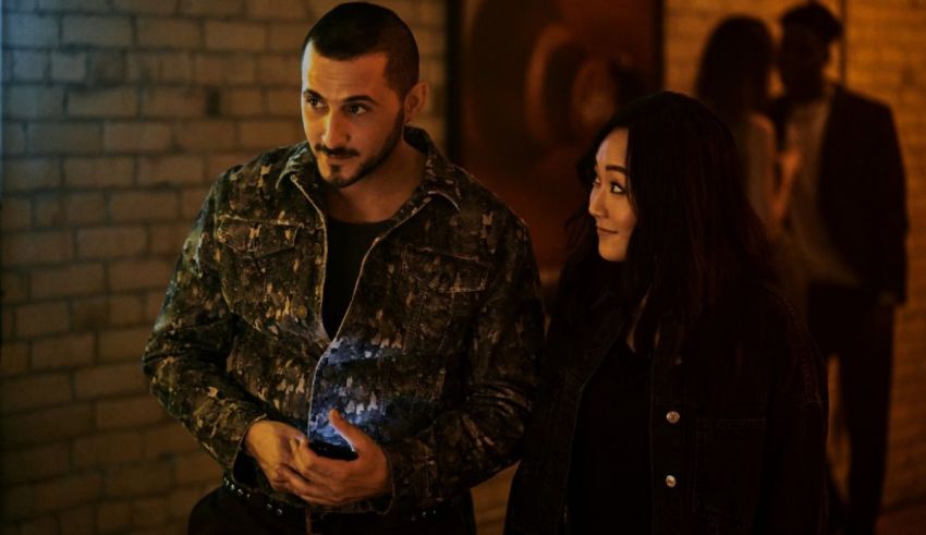 A man and woman standing next to each other in a dark hallway.