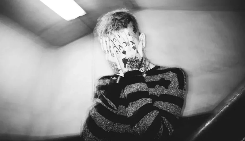 A black and white photo of a man covering his face.