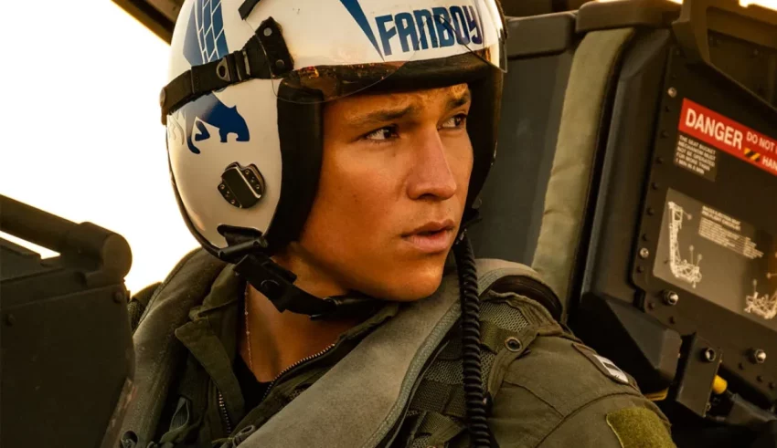 A young man wearing a helmet in a helicopter.