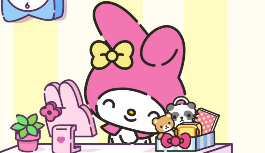 Hello kitty in a pink hat sitting at a desk.