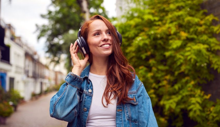 A young woman listening to music in a park.