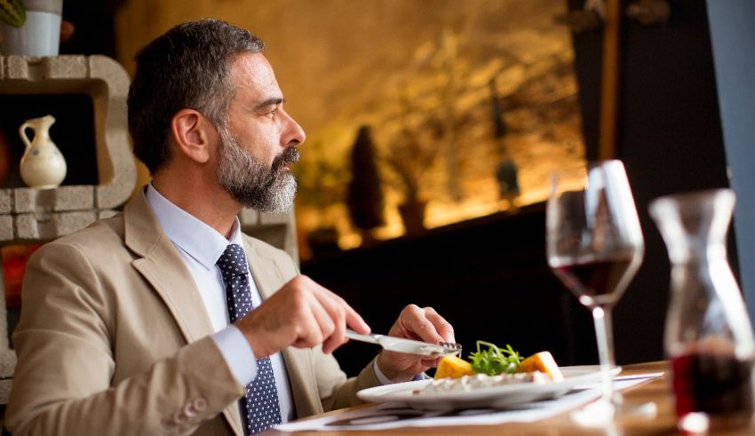 A man in a suit is eating a meal in a restaurant.