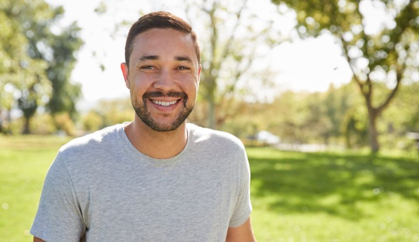 A smiling man in a park.