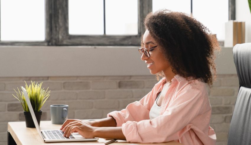 A woman working on a laptop in an office.