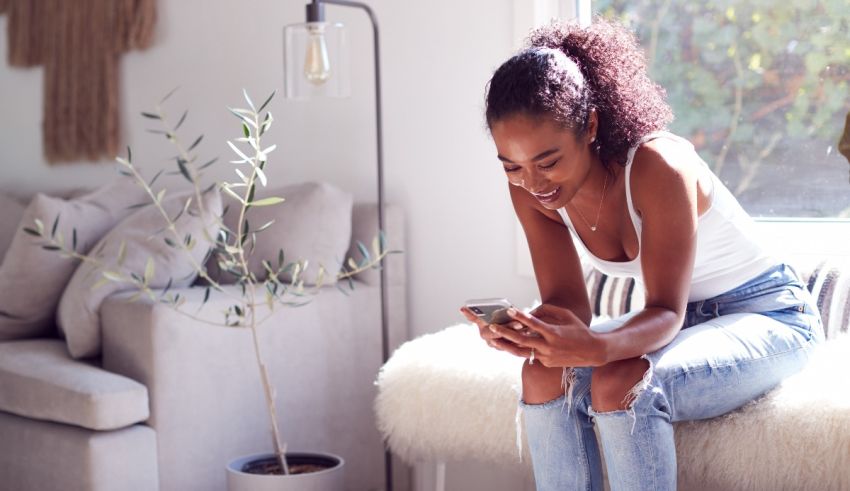 A woman sitting on a couch looking at her phone.