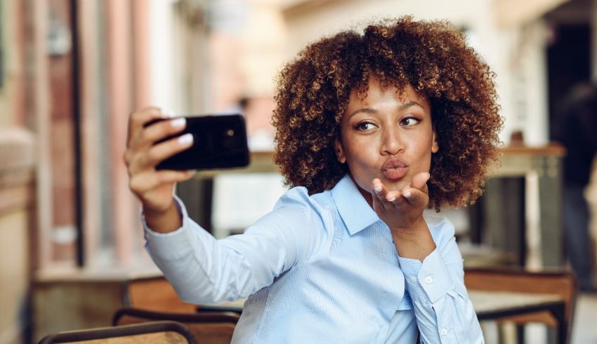 A young woman taking a selfie with her cell phone.