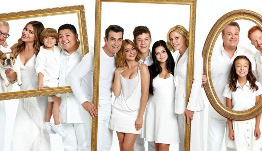 A group of people are posing in front of a white frame.