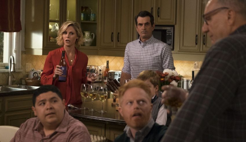 A group of people standing around in a kitchen.