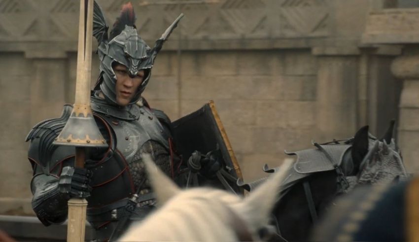 A man in armor is standing next to a horse.