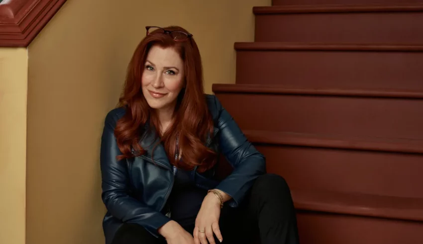 A woman in a black leather jacket sitting on steps.