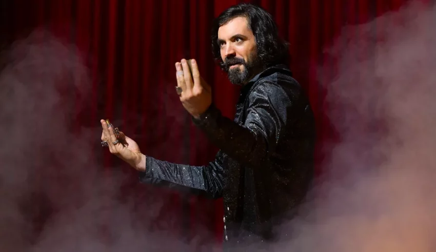 A man with a beard standing in front of smoke.