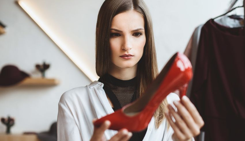 A woman looking at a red shoe in a store.