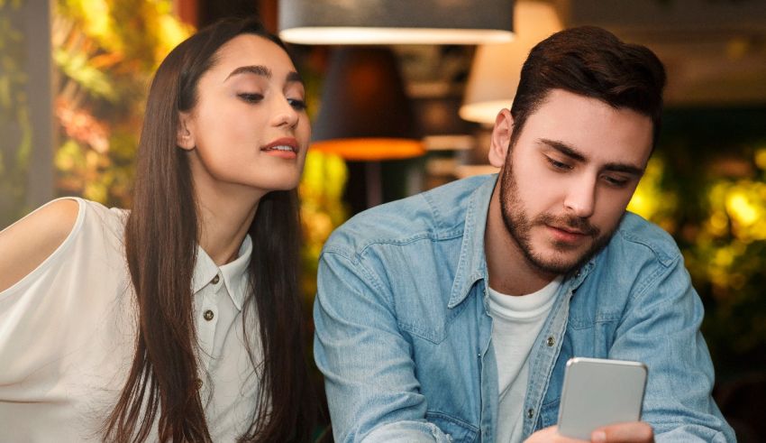 A man and woman looking at a cell phone in a cafe.