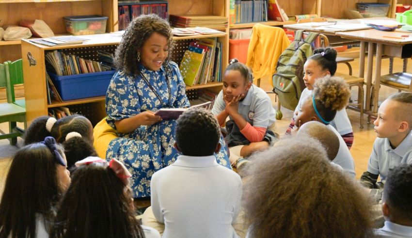 A woman reading a book to children in a classroom.