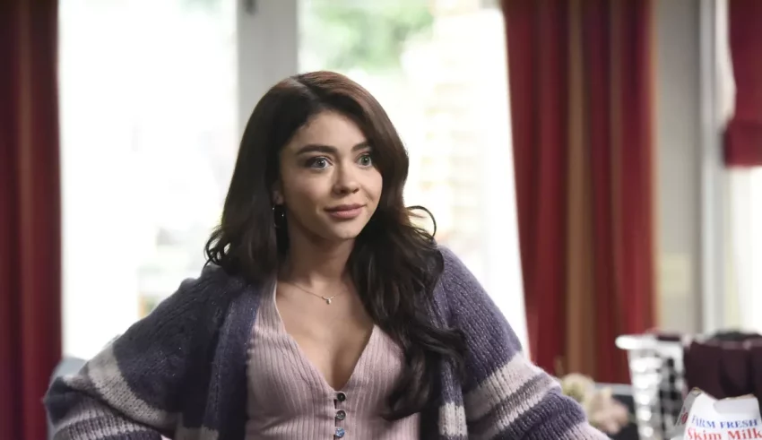 A woman in a purple sweater standing in a kitchen.