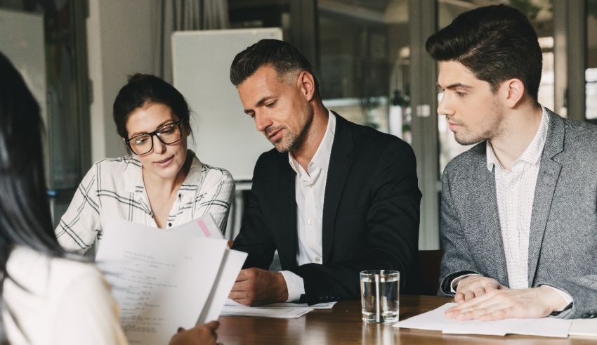 A group of people sitting around a table in a meeting.