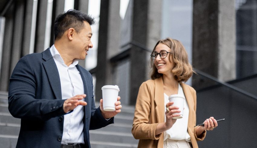 Two business people talking on the steps of an office building.