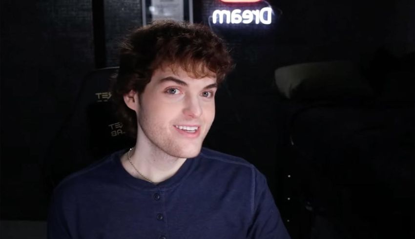 A young man sitting in a room with a dream sign.