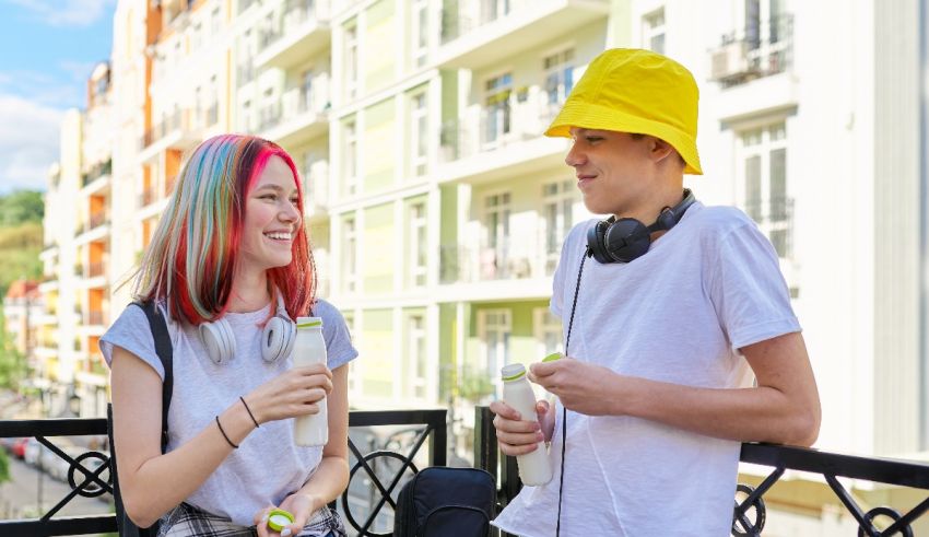 Two young people are sitting on a balcony talking to each other.